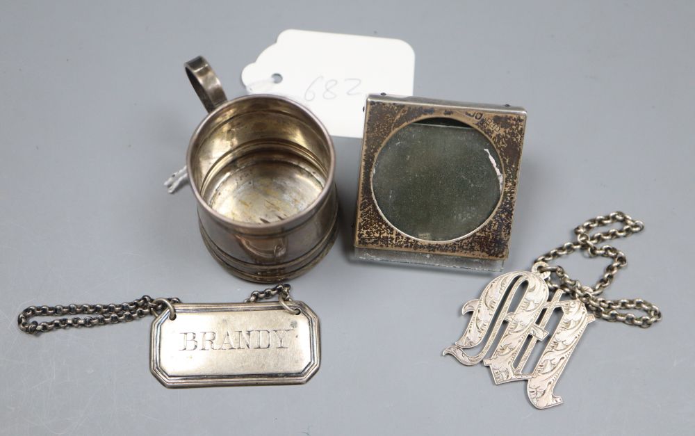 An Edwardian miniature silver mug, a similar photograph frame and two silver wine labels.